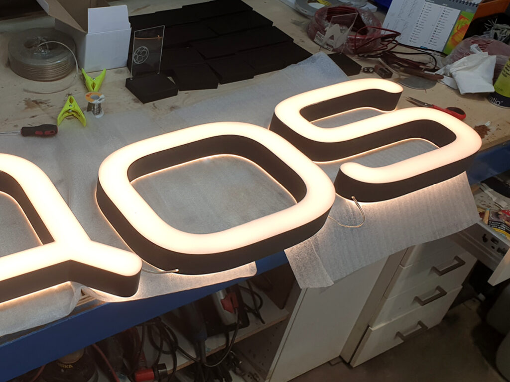 Realizzazione insegna luminosa in facciata per punto vendita Iqos - TraSparente Group